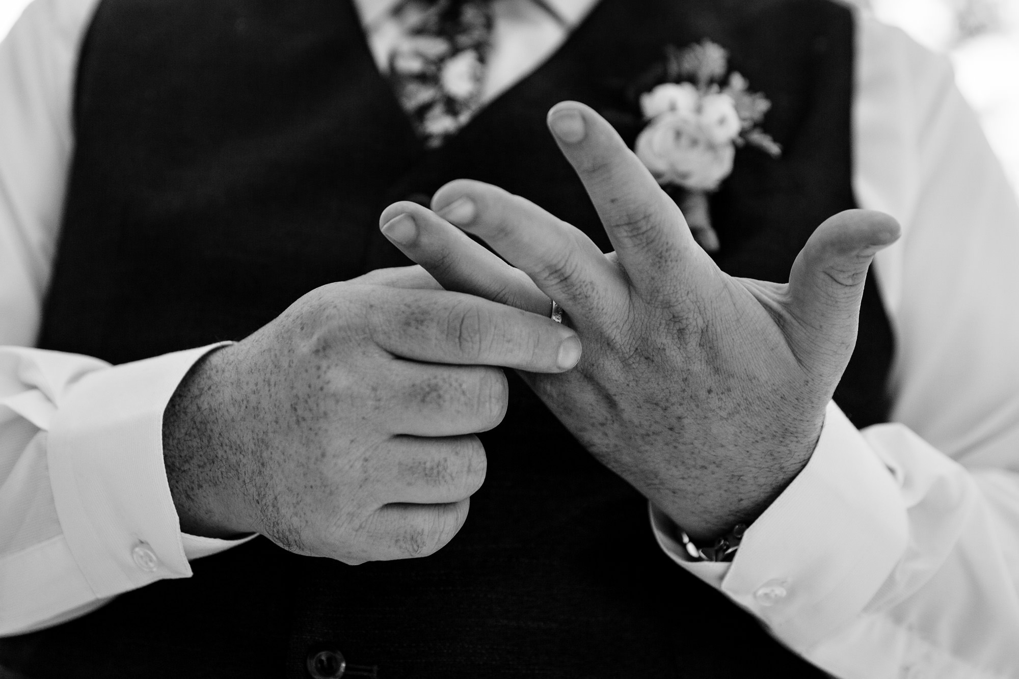 A groom plays with his ring at his wedding in Maine