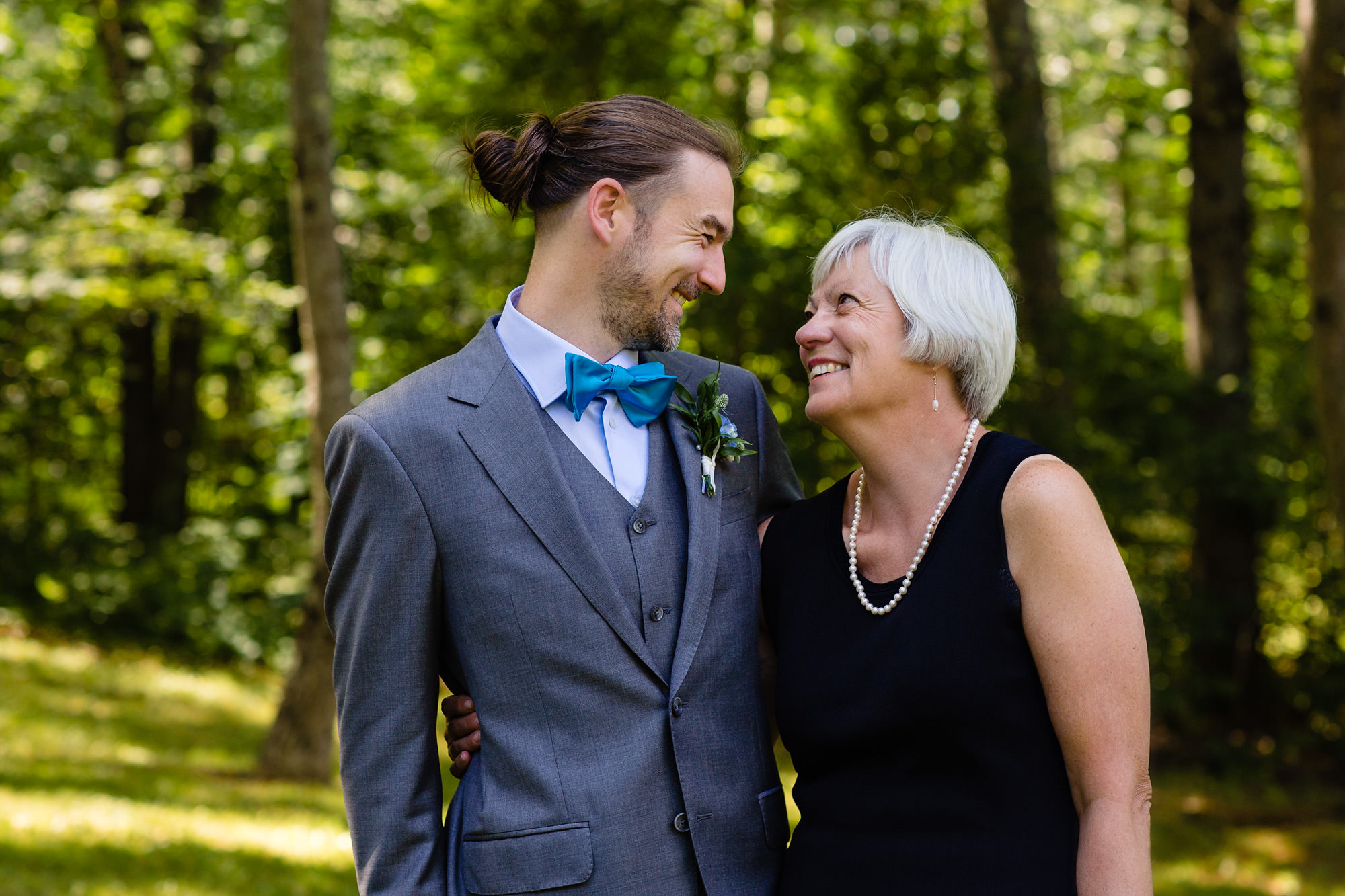 A groom and his mother share a poignant moment at a lakeside Maine wedding