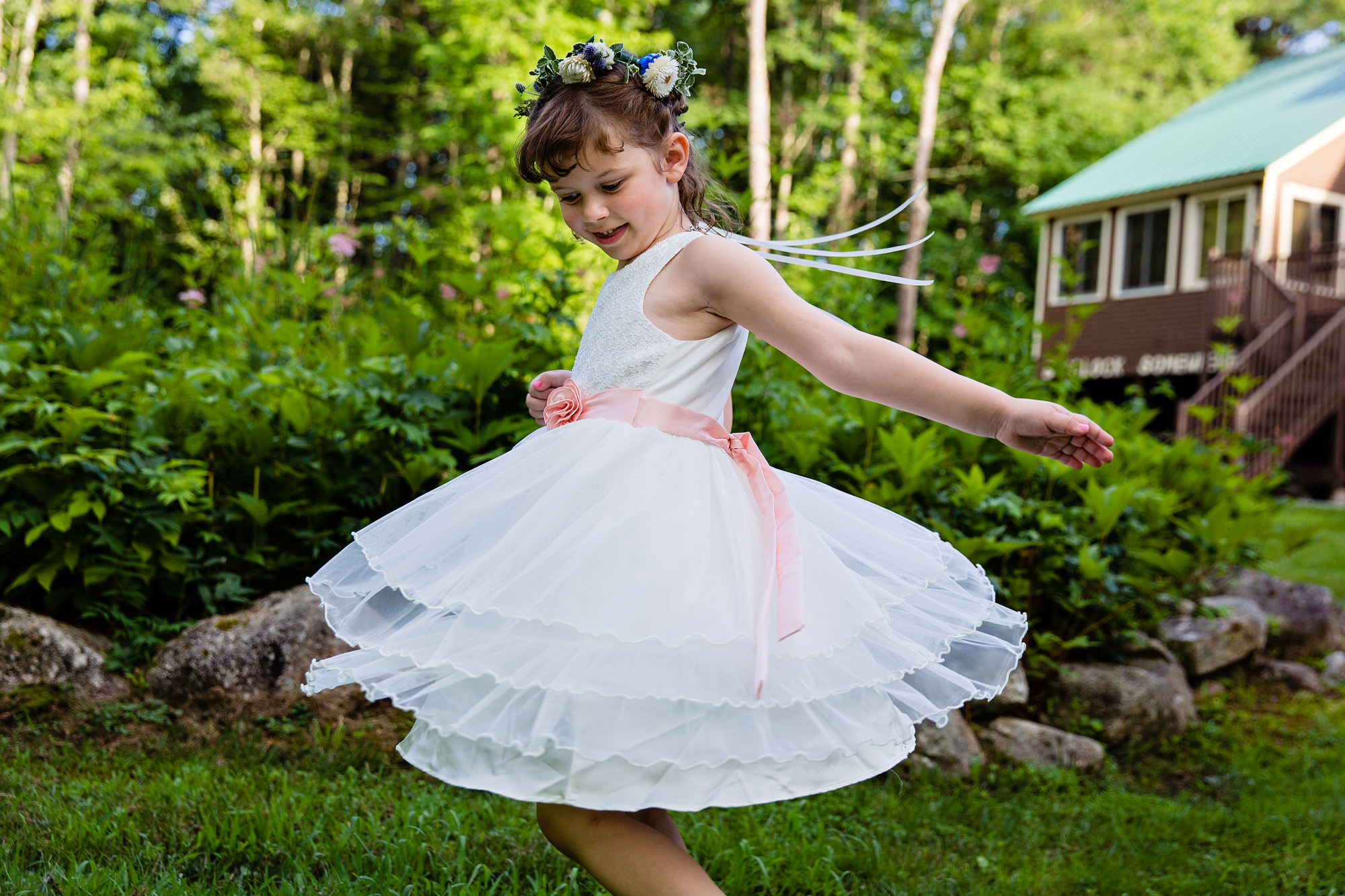 The flower girl twirls at a Maine wedding