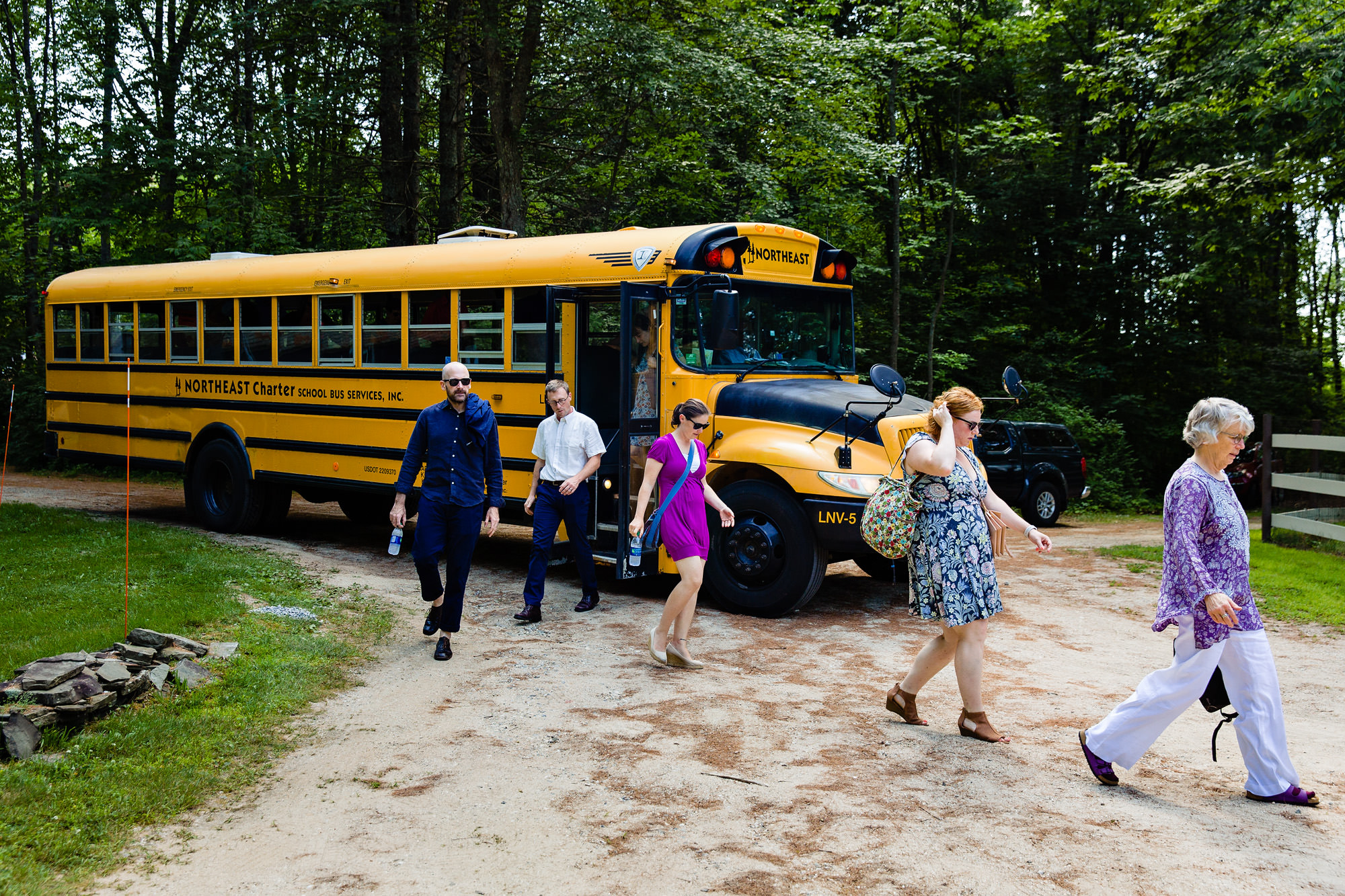 Guests arrive via school bus to a private residence wedding in Maine
