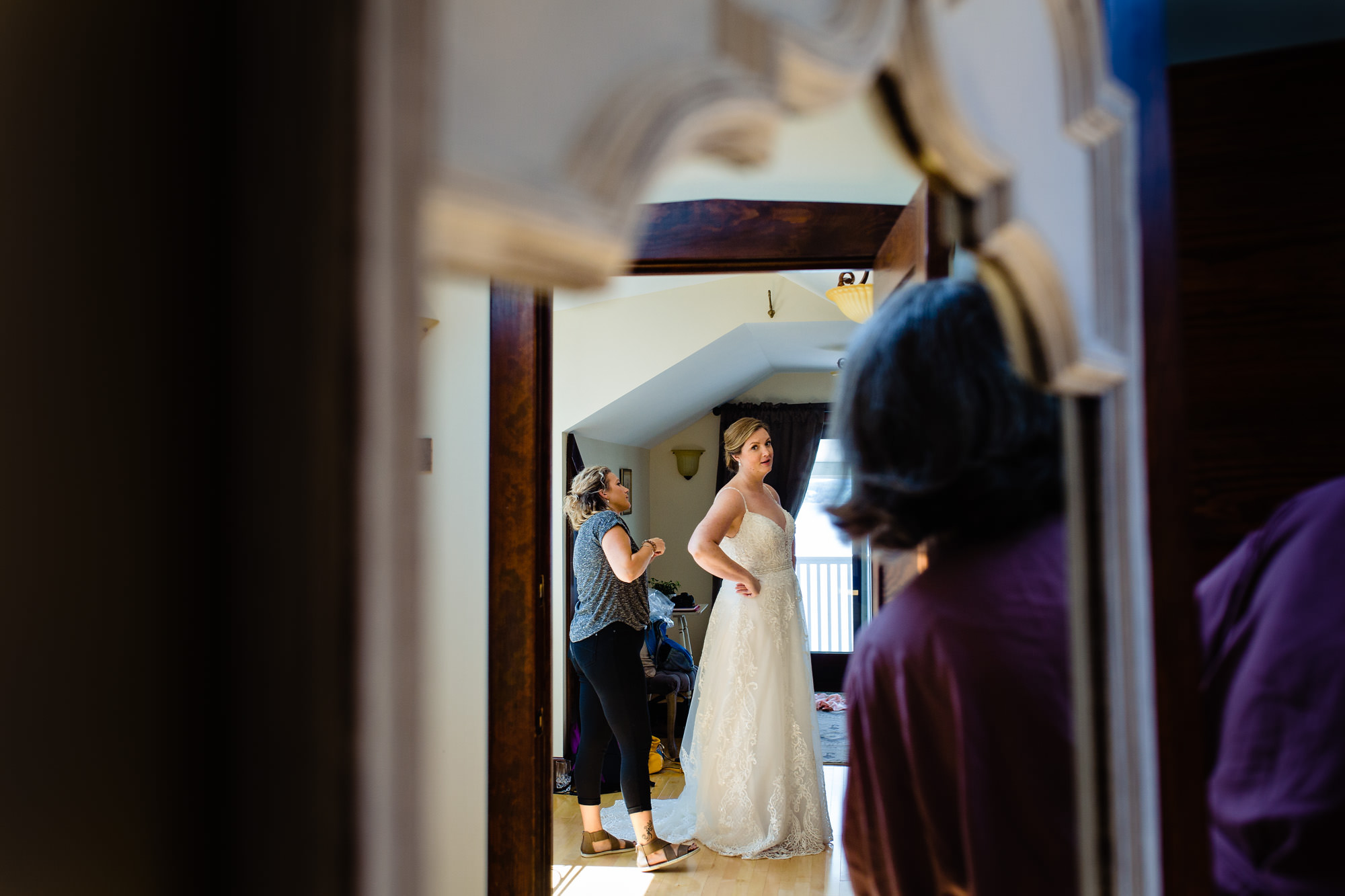 The mother of the bride looks in on the bride as she gets dressed