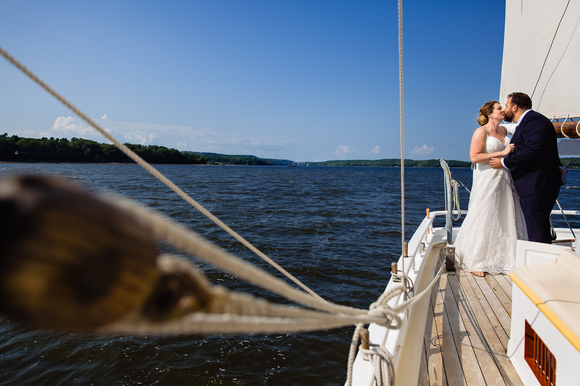 Wedding portraits of the bride and groom on a sailboat at French's Point in Maine