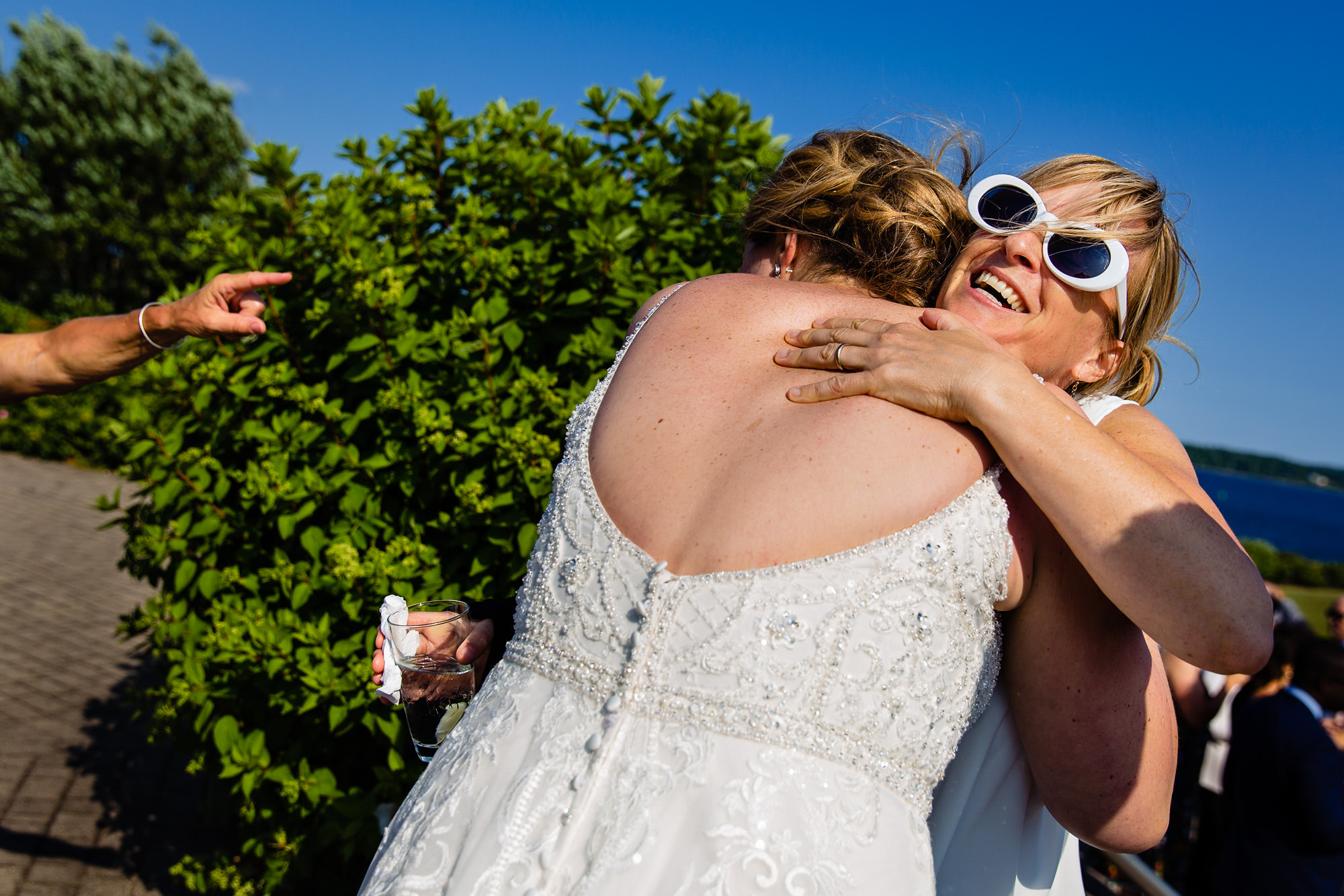 The bride hugs a friend at a wedding in Maine