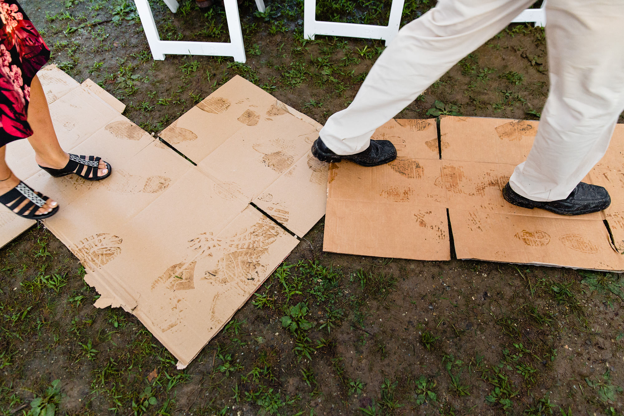 Cardboard is placed down on the floor of the tent in order to sop up the mud at a Maine wedding
