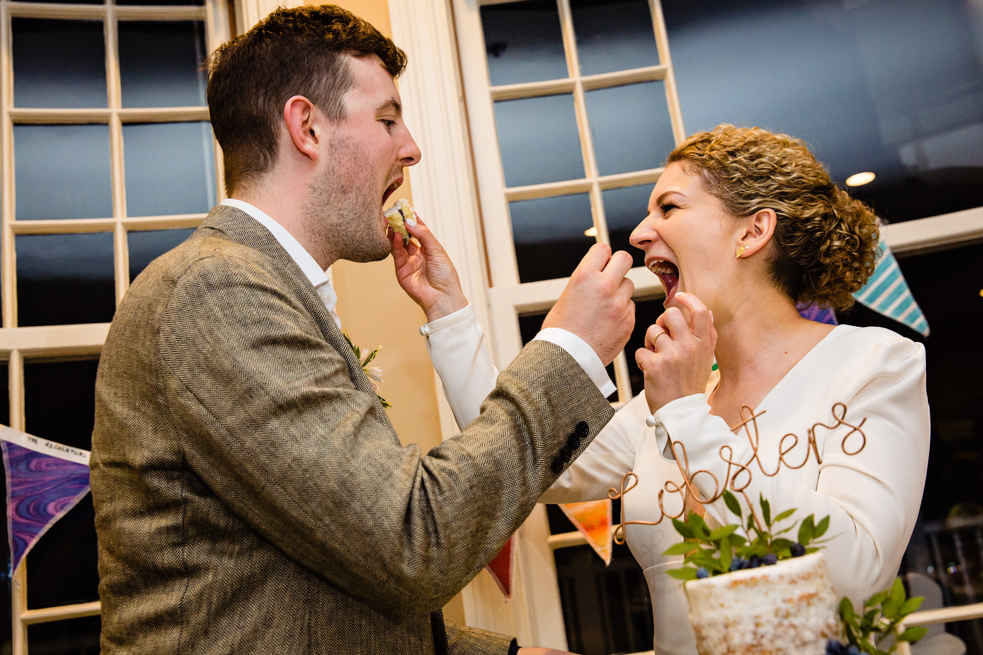 The bride and groom cut and eat their wedding cake at their Bar Harbor Inn wedding