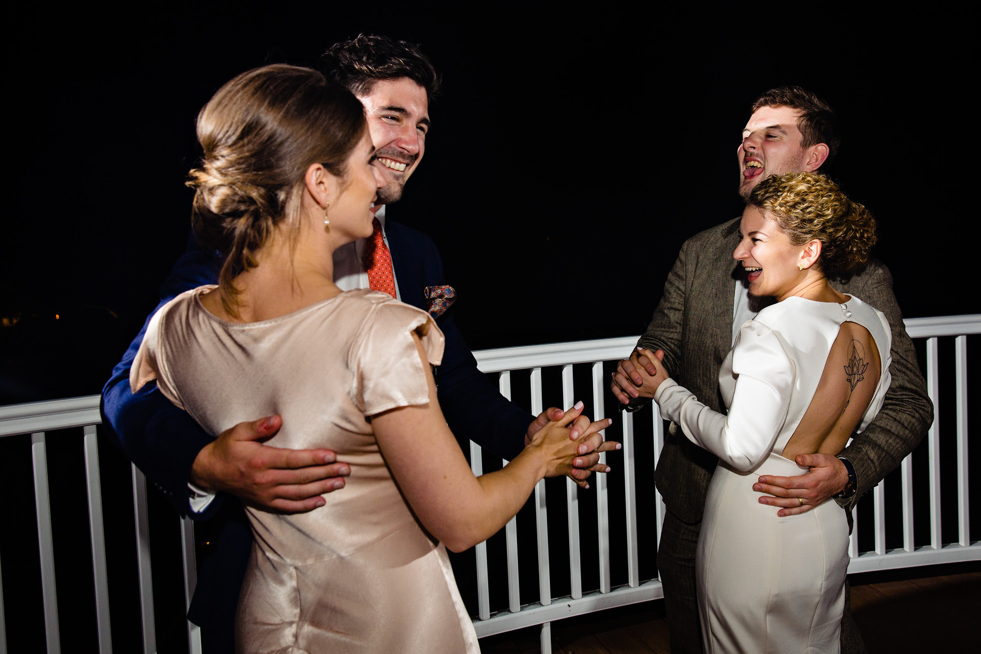 The bride, groom, and their guests dance on the Bar Harbor Inn's porch as night falls
