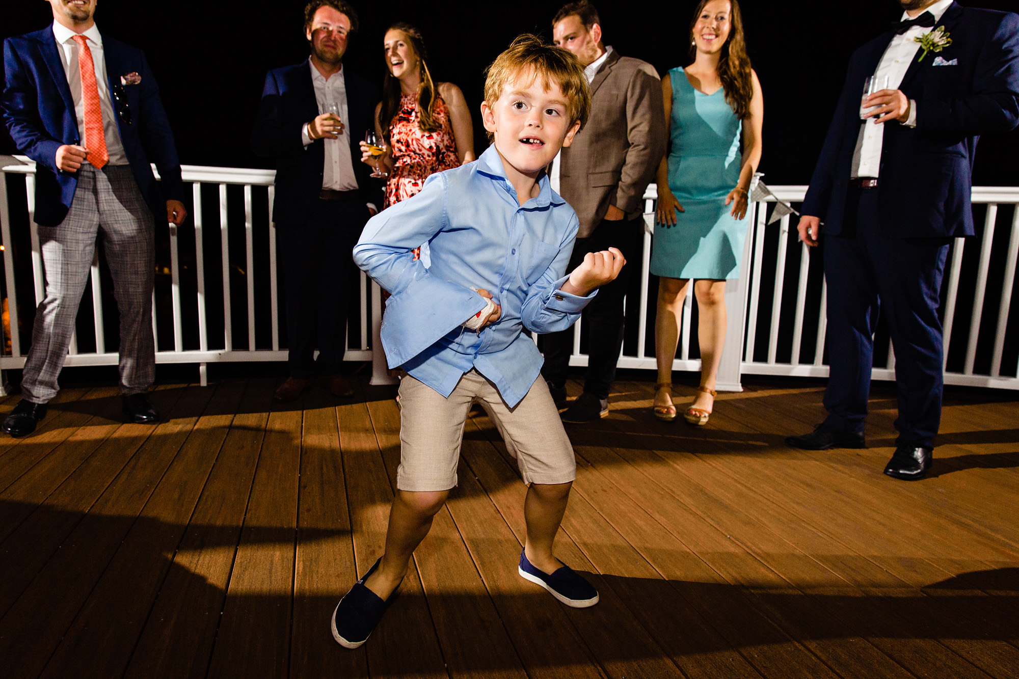 The bride, groom, and their guests dance on the Bar Harbor Inn's porch as night falls