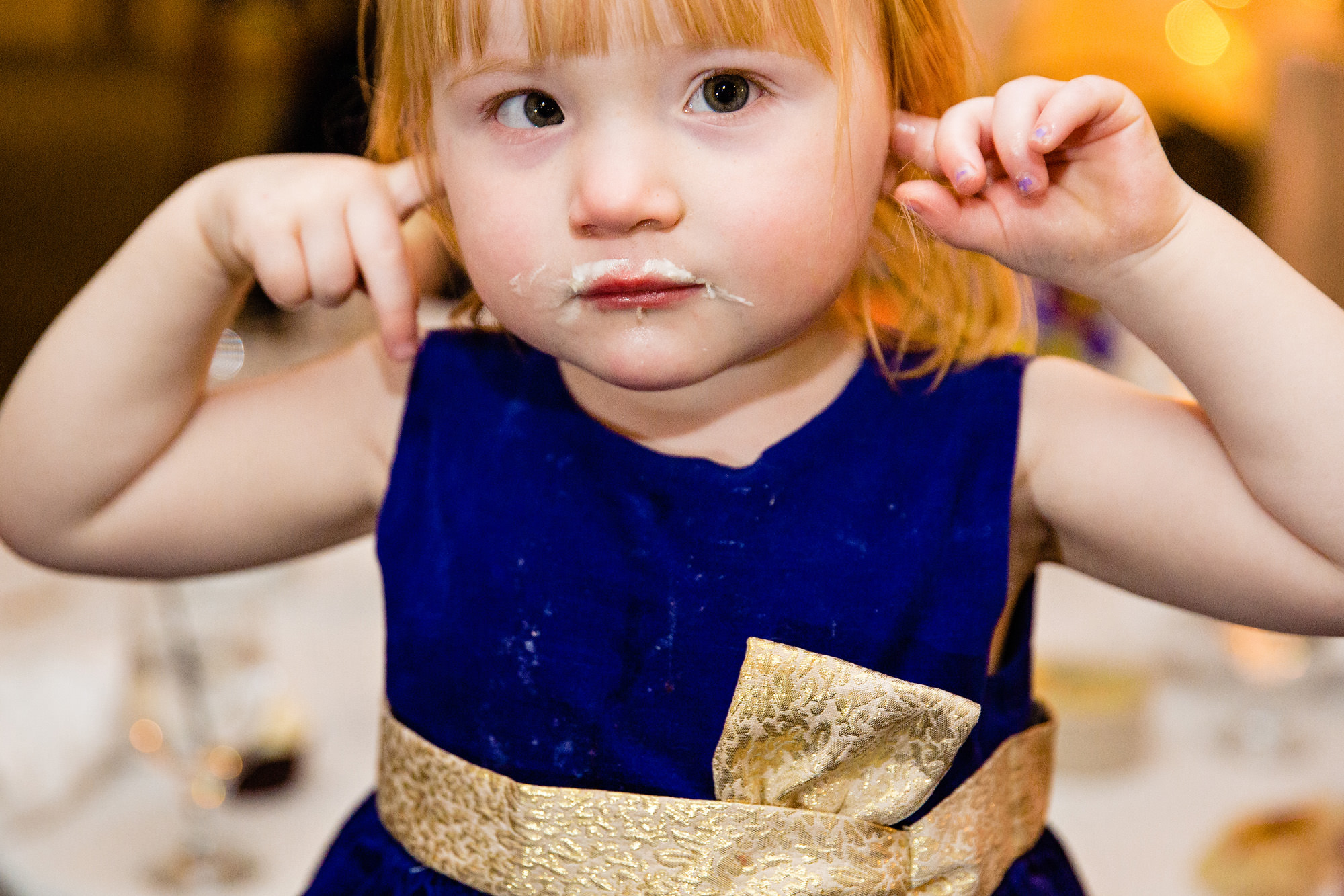 A young girl plugs her ears at a Freeport, Maine wedding