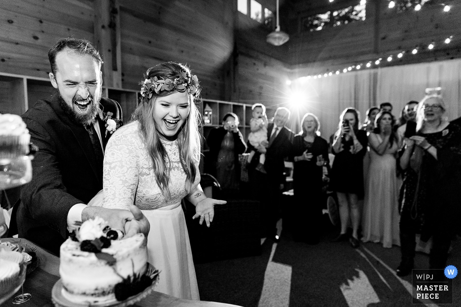 A bride and groom cut the cake at their Sugarloaf Maine wedding