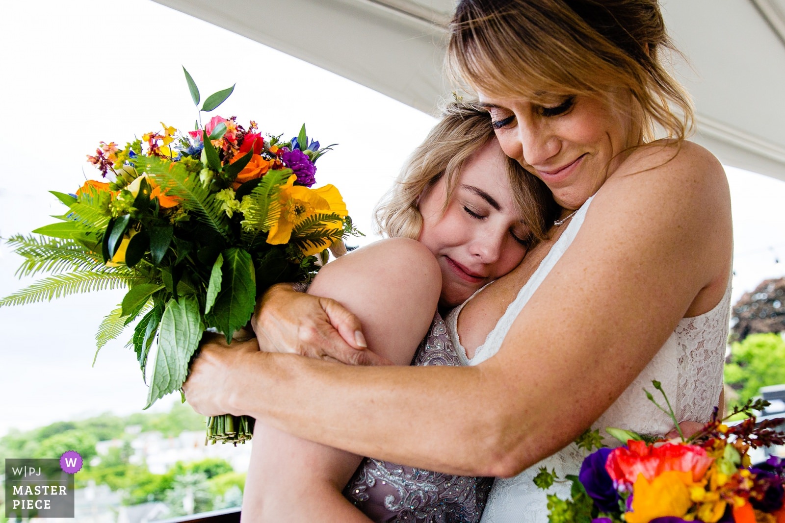 A bride and her daughter hug after her wedding ceremony in Camden, Maine