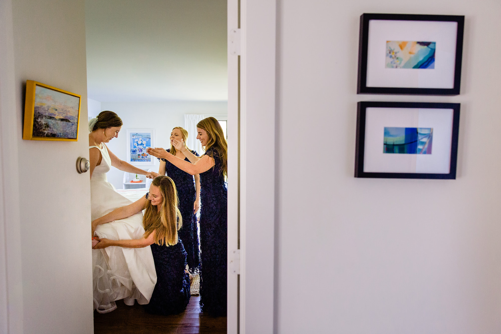 A bride gets dressed with her bridesmaids at her Blue Hill Maine wedding