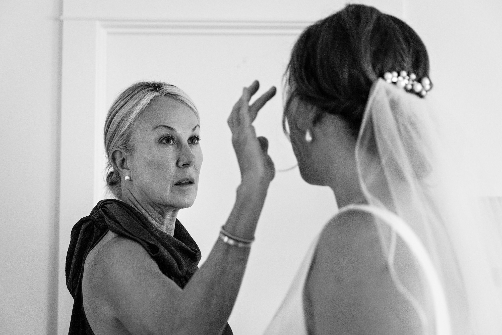 The mother of the bride fixes the bride's hair at her Blue Hill Maine wedding