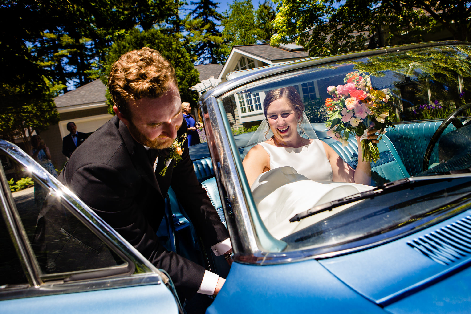 The bride and groom exit their wedding via an antique car in Maine