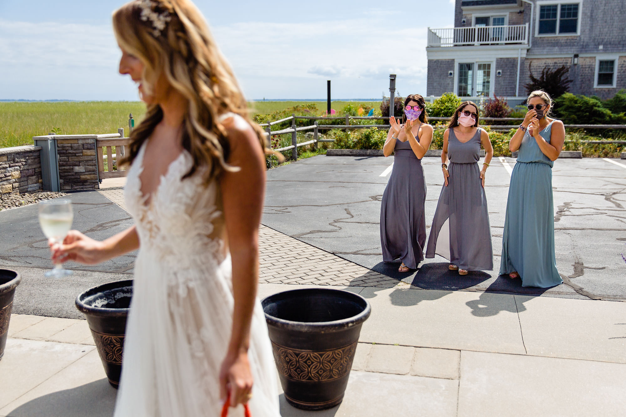 A bride shows her dress to her friends at her southern Maine wedding