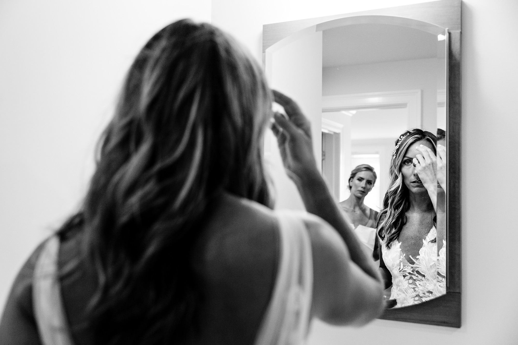 A bride looks in the mirror right before her southern Maine beach wedding