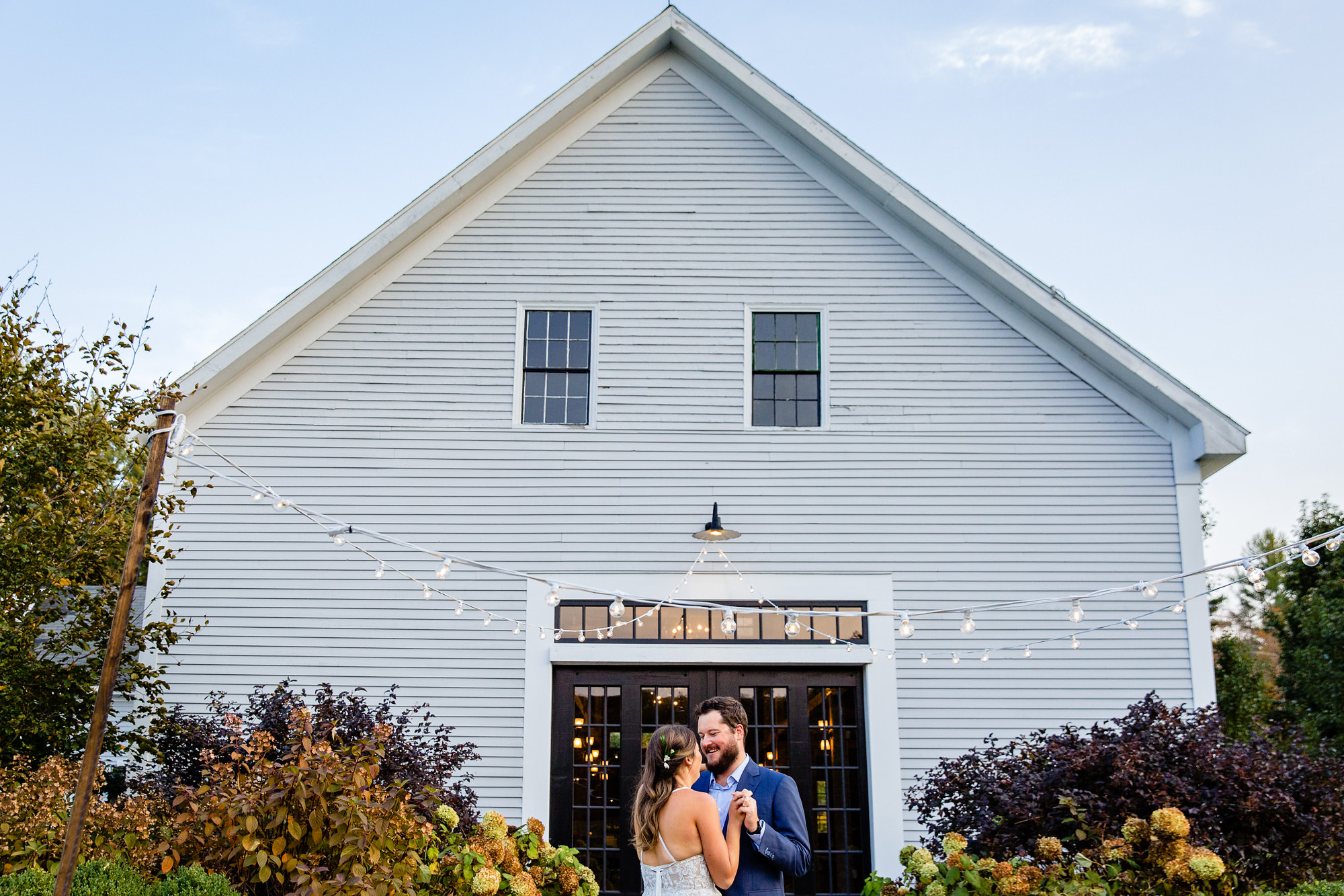 The bride and groom dance in front of The Barn at Flanagan Farm in Maine