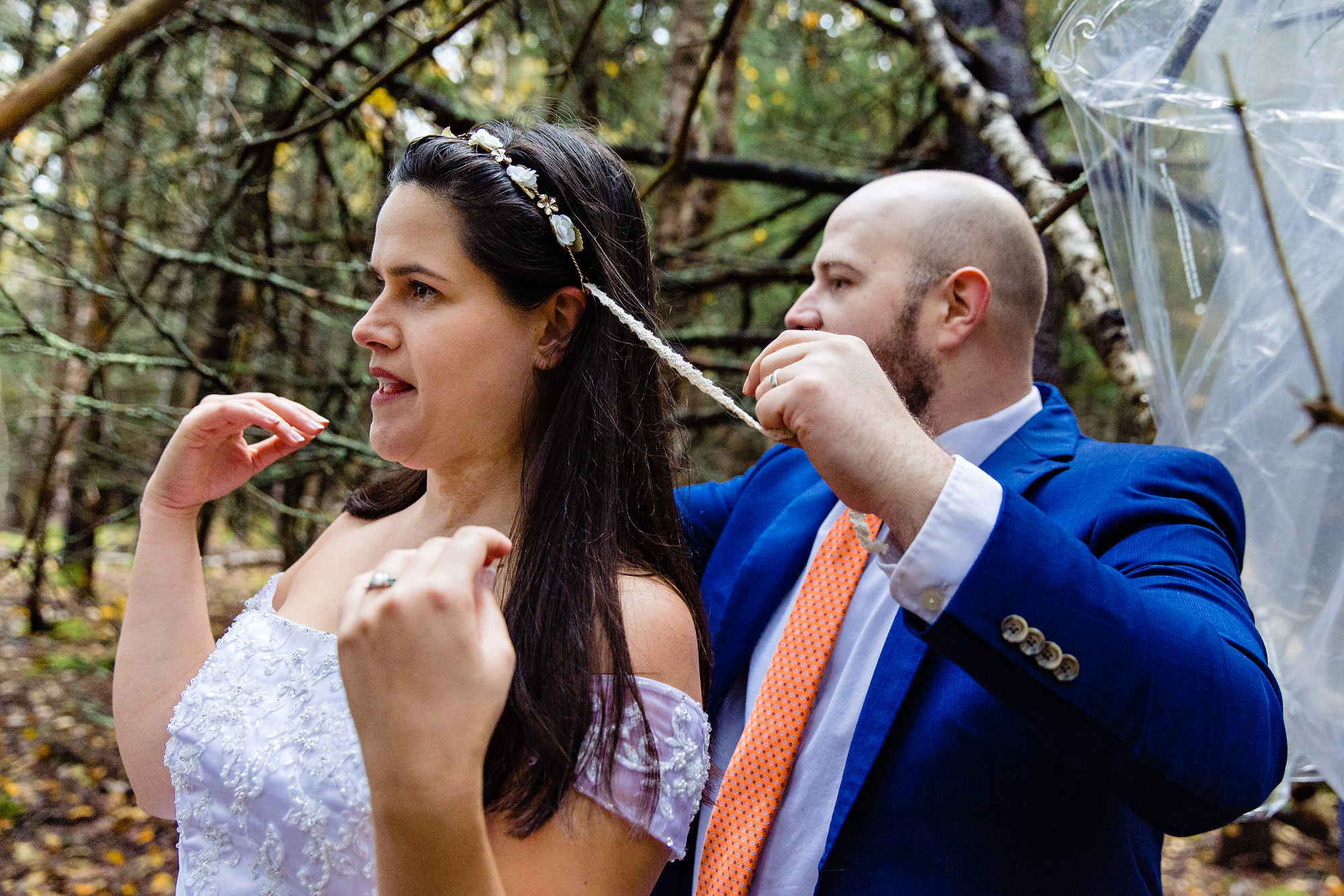 A bride and groom get dressed in the woods for their elopement at Acadia National Park