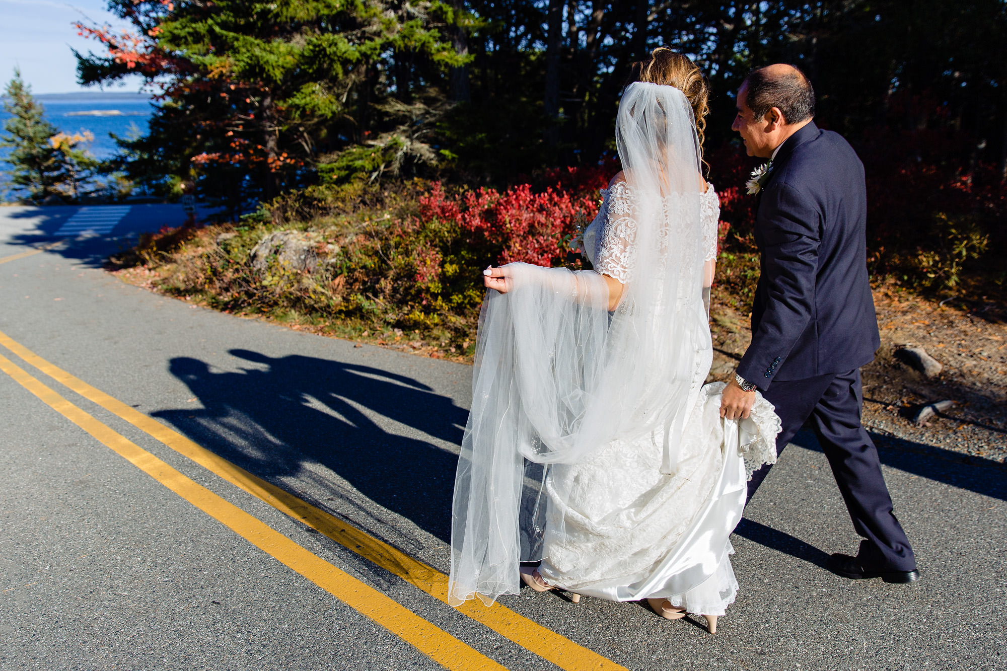 A bride and groom walk toward the cliffs where they will have their wedding ceremony in Acadia