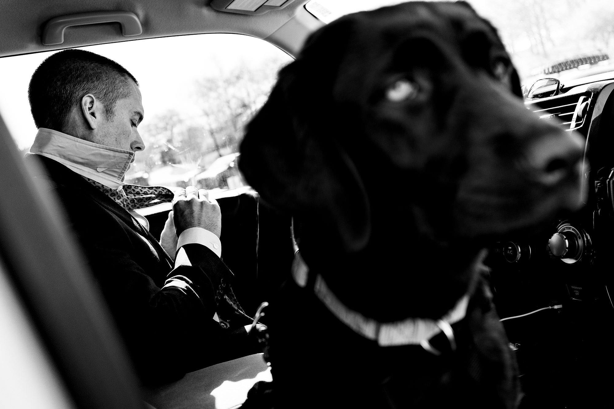 A groom gets ready in their car for their Portland Head Light elopement in Maine