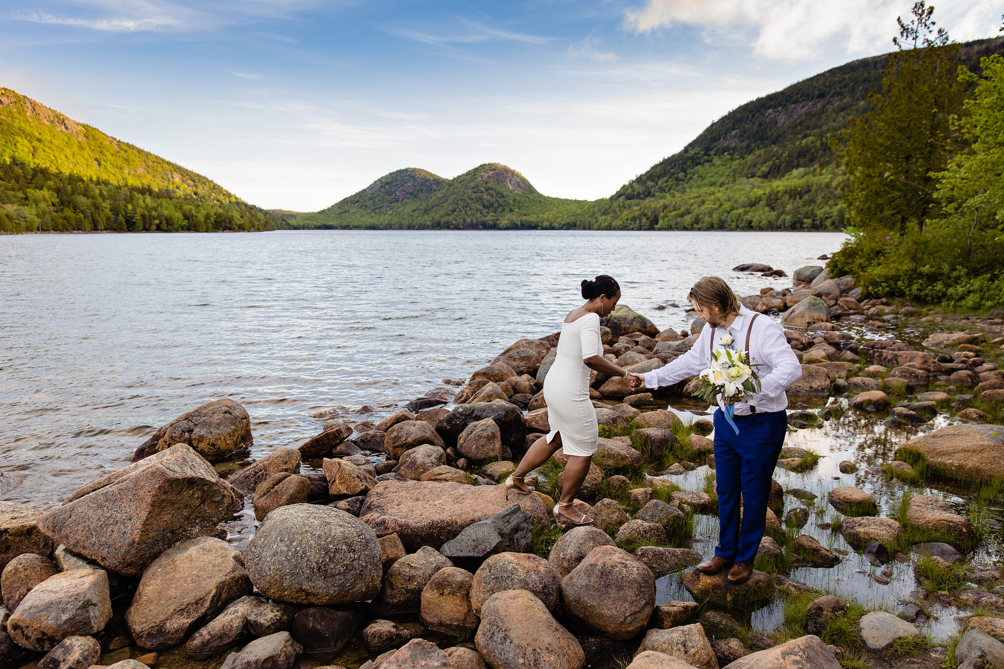 A wedding couple takes portraits in front of Jordan Pond in Acadia
