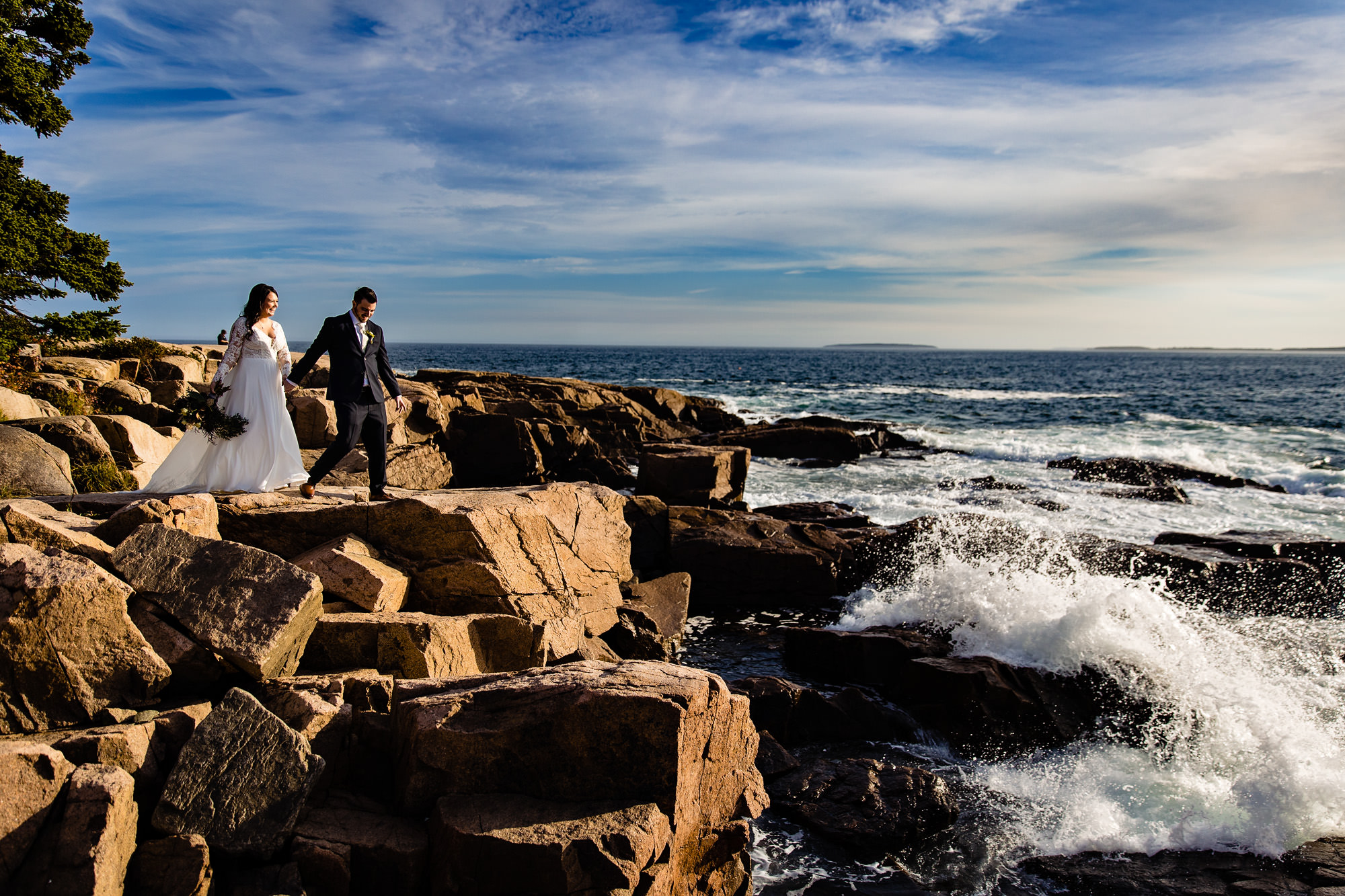 A wedding couple walk along the cliffs in Acadia