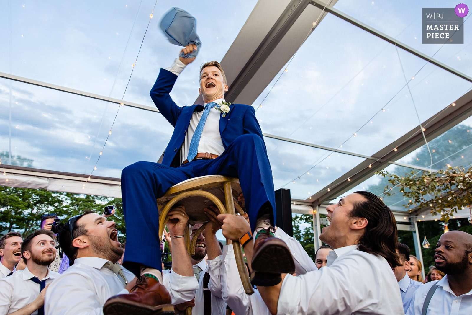 A groom is lifted at a wedding at Marianmade Farm in Maine