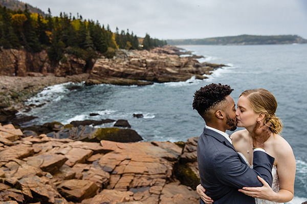 A couple kiss on the cliffs in Acadia at their elopement