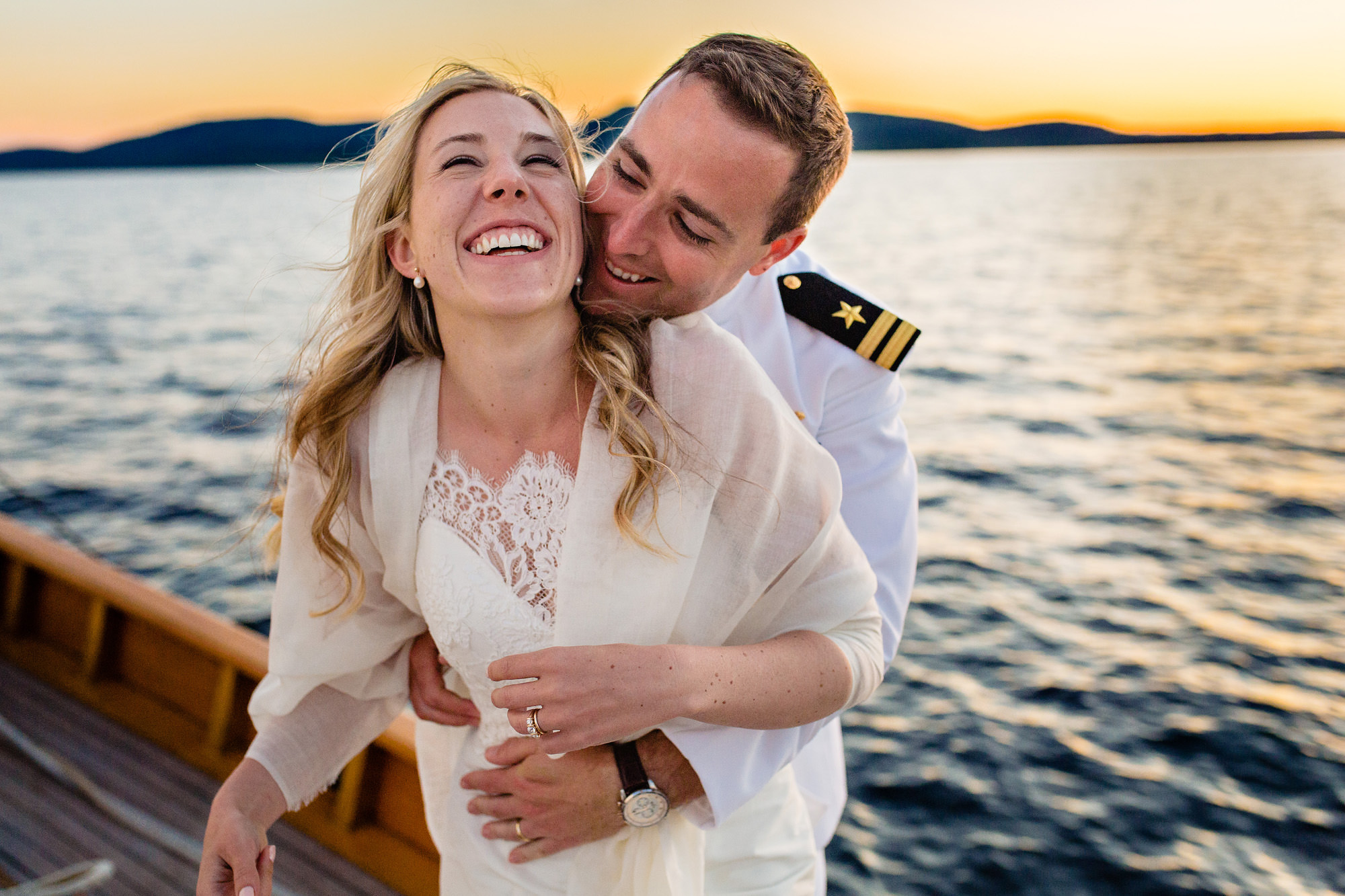 A couple embraces during an elopement on a sailboat in Camden, Maine