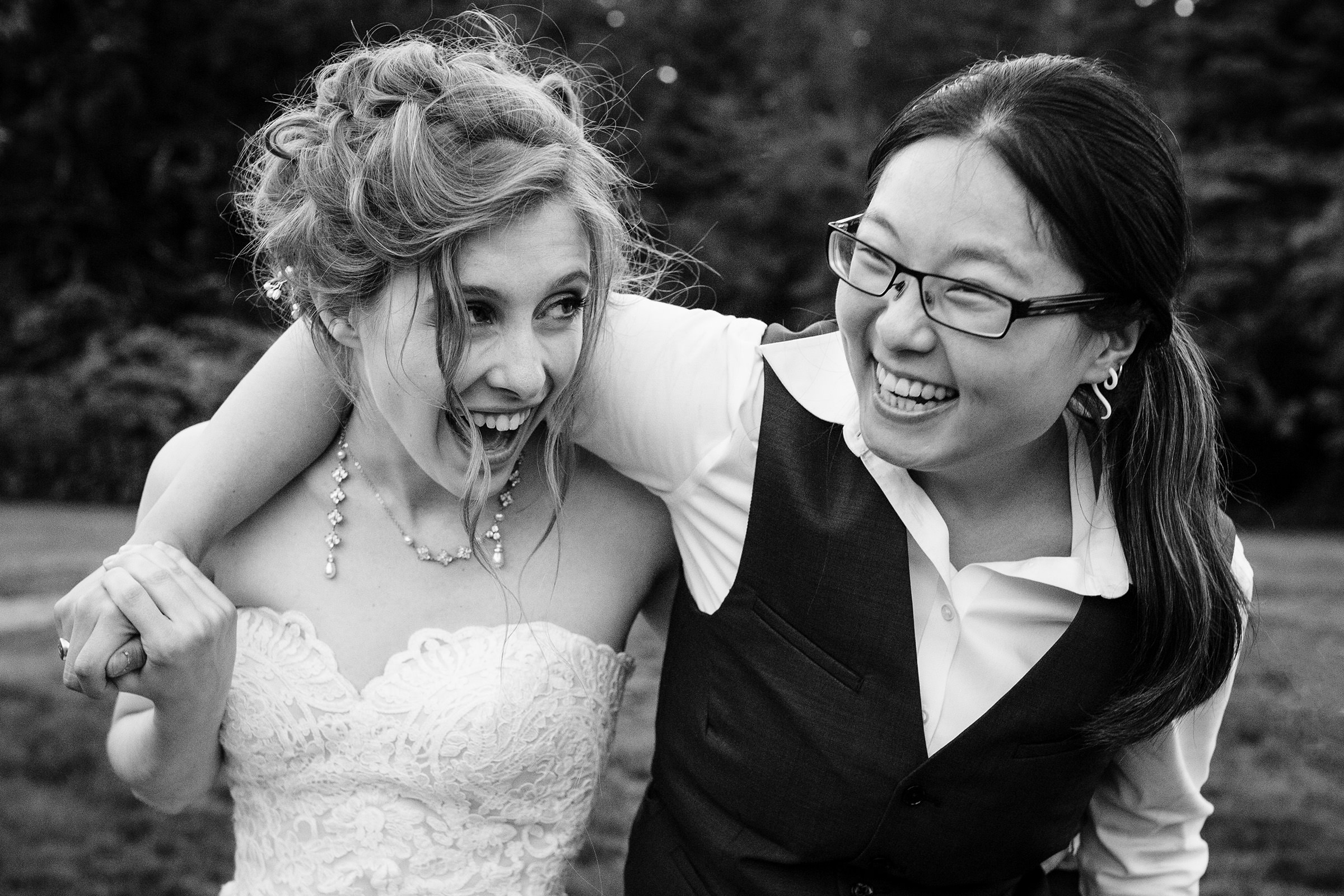 Two women throw their arms around each other at a Brooklin Maine wedding