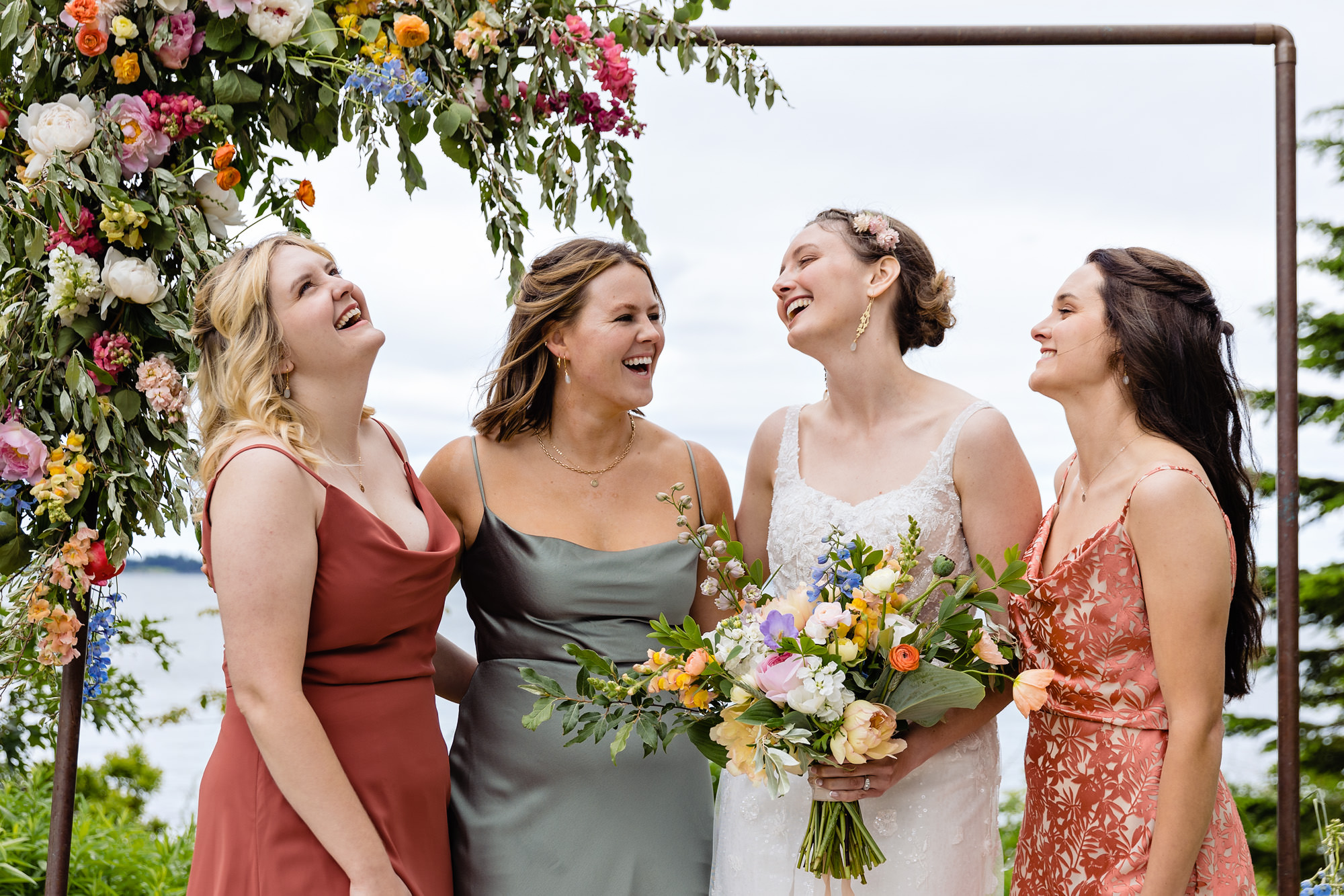 The bride laughs with her bridesmaids at her Chebeague Island wedding
