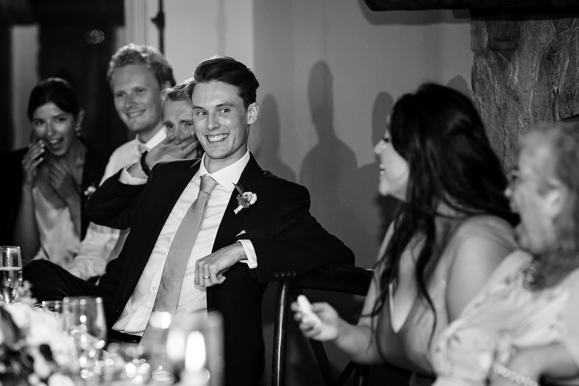 The groom laughs during a toast