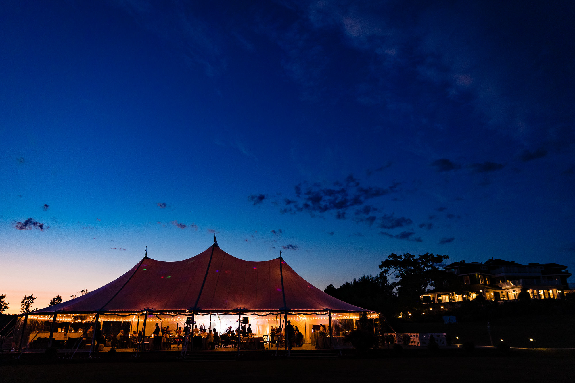 A wedding reception under a sailcloth tent at a midcoast wedding in Maine