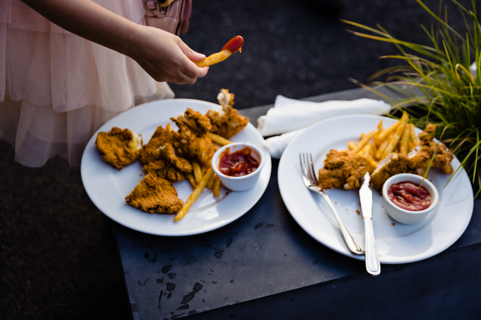 A girl eats chicken nuggets and fries at a View at Pepperrell Cove wedding