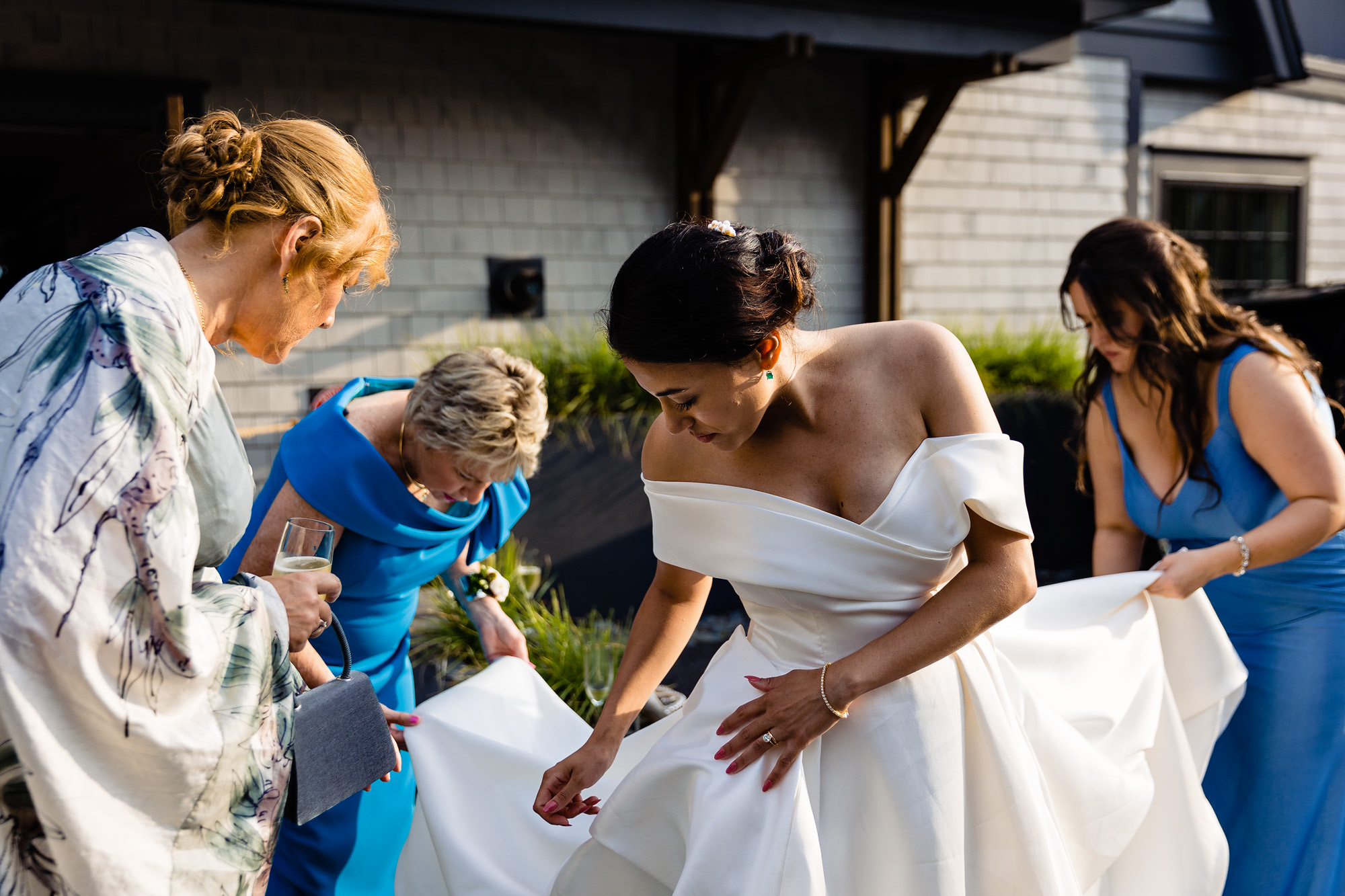 Friends and family of the bride help her bustle her wedding dress