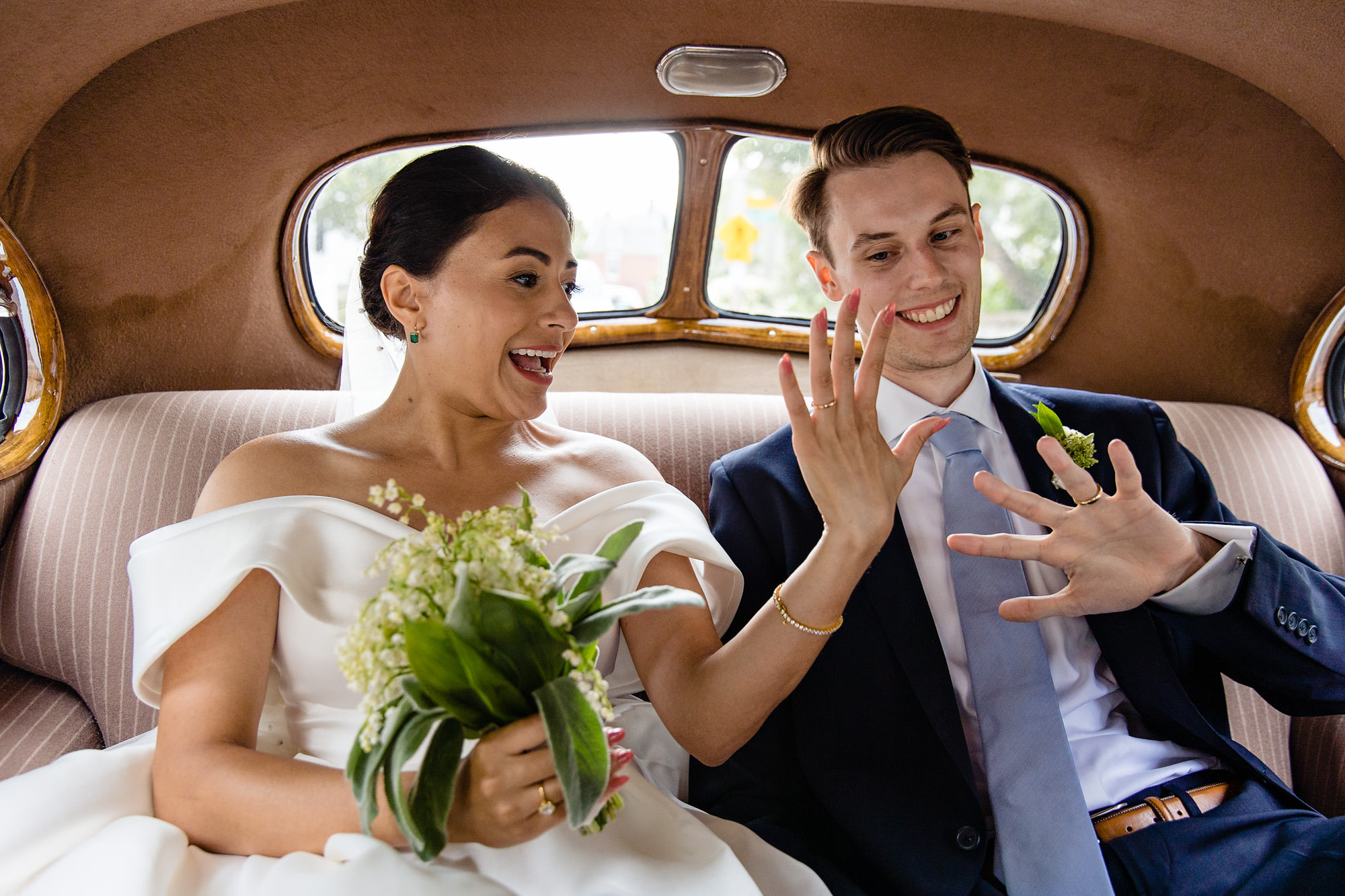 A wedding couple check out their new wedding rings in the back of a vintage car in Portsmouth, NH