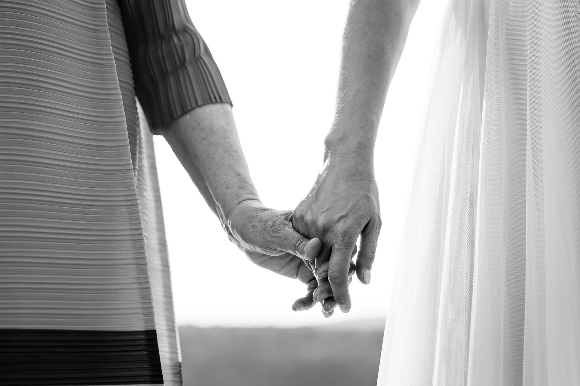 The bride and her mom hold hands during an Acadia elopement ceremony