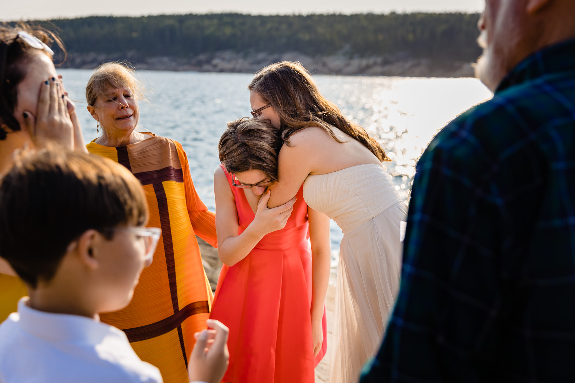 The bride embraces her daughter while her new step-daughter cries