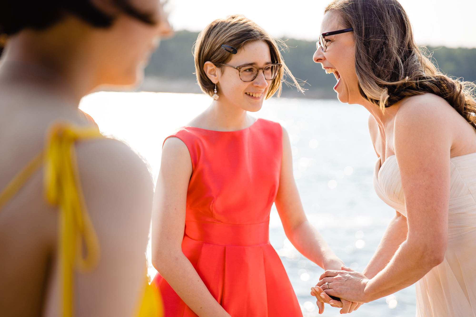 The bride holds her daughter's hand and laughs during an Acadia elopement