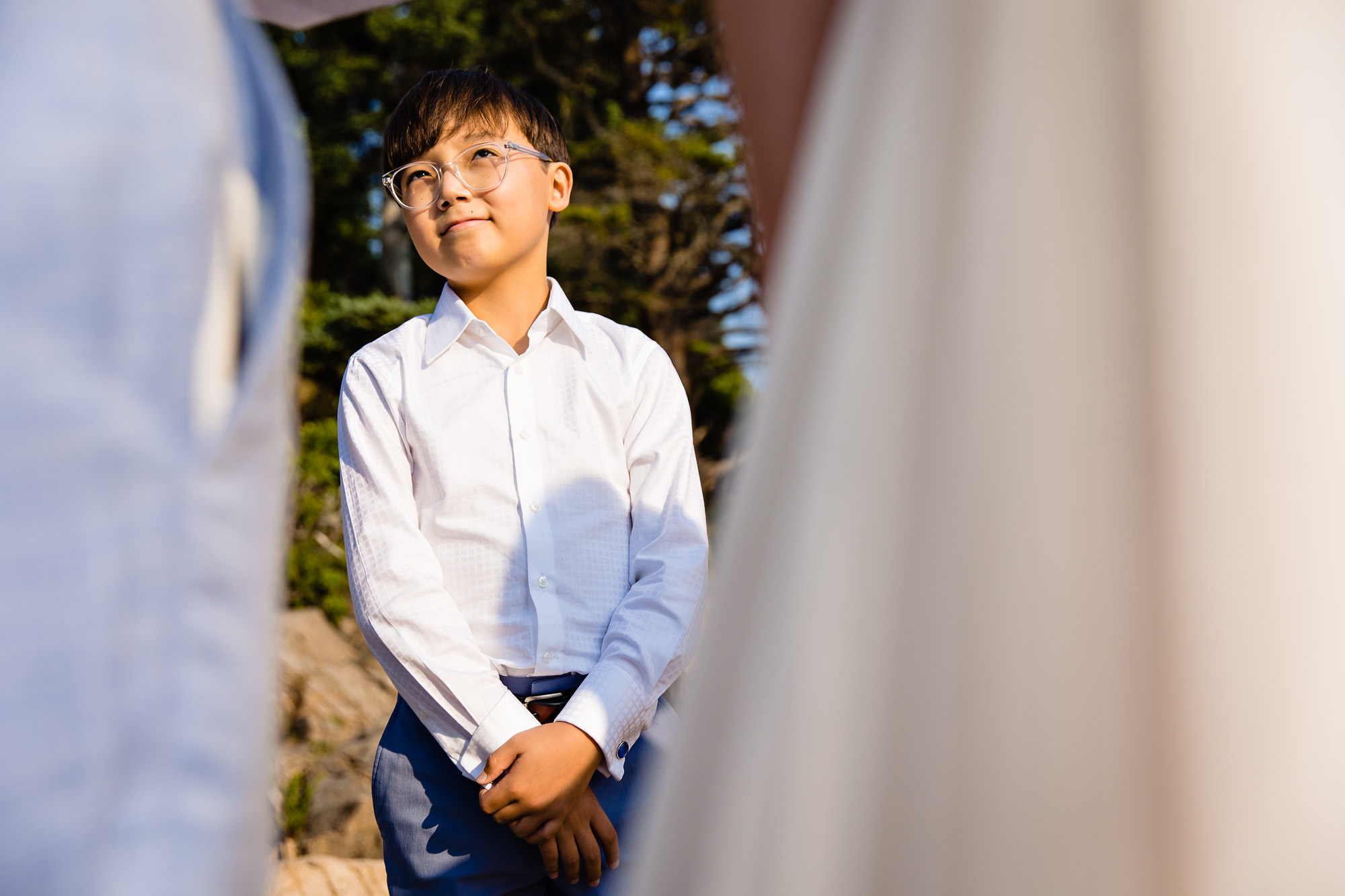 The groom's son looks up at his dad during an Acadia elopement ceremony