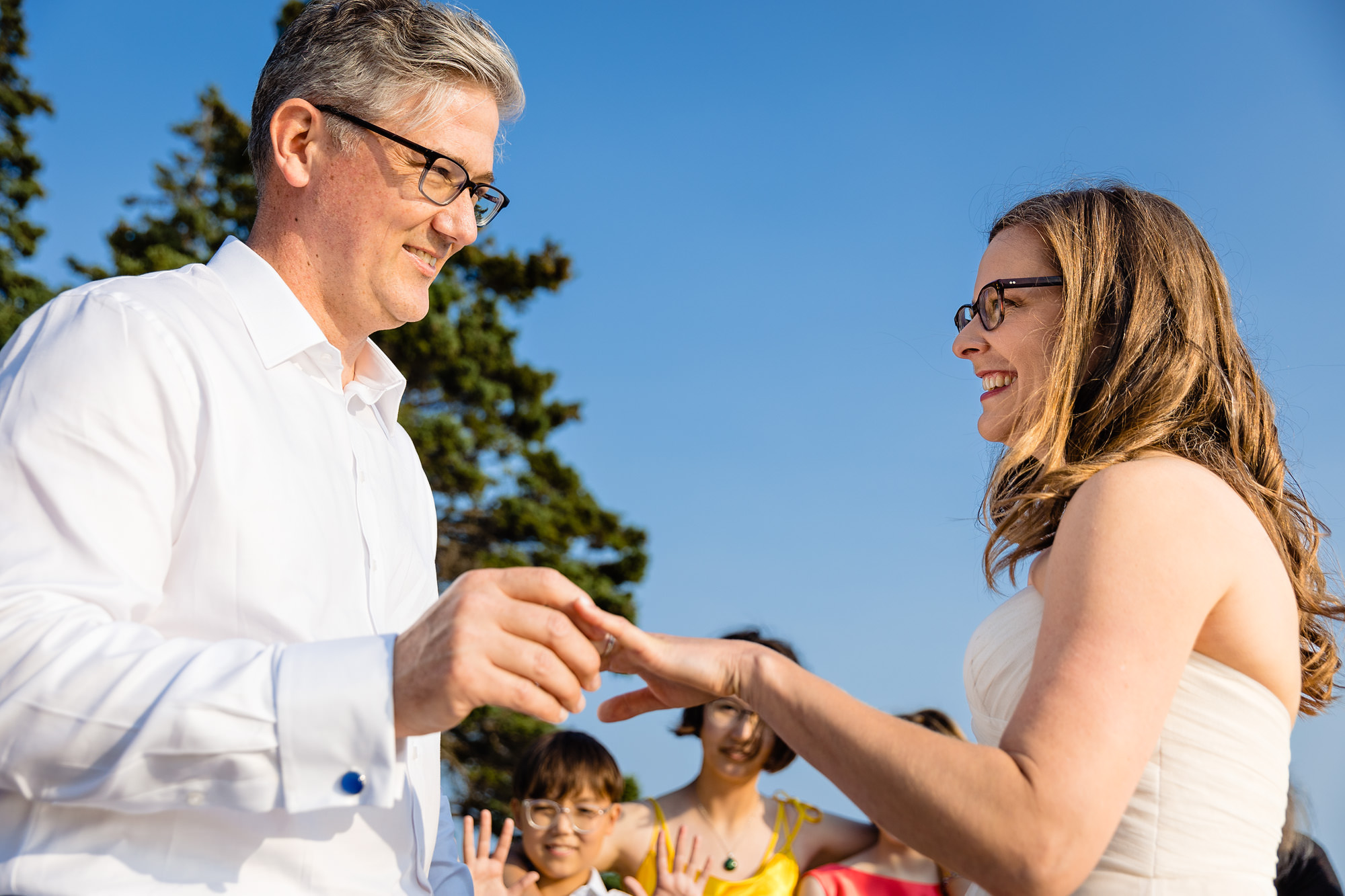 The wedding couple put on their rings during their Acadia elopement ceremony