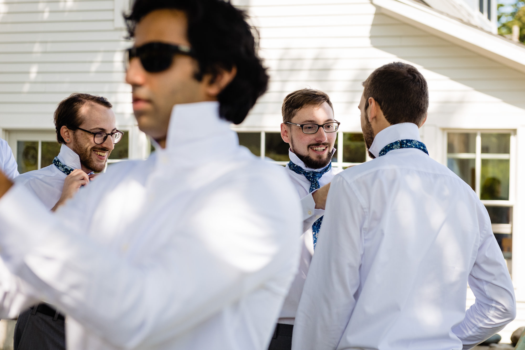 A groom gets ready outside for his wedding on Swans Island, Maine