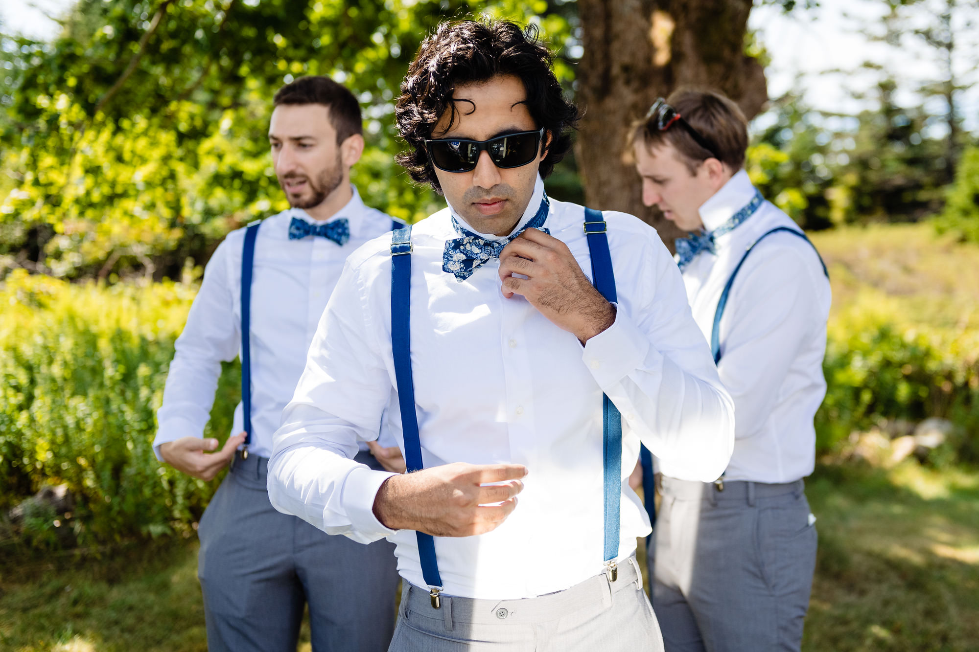 A groom gets ready outside for his wedding on Swans Island, Maine