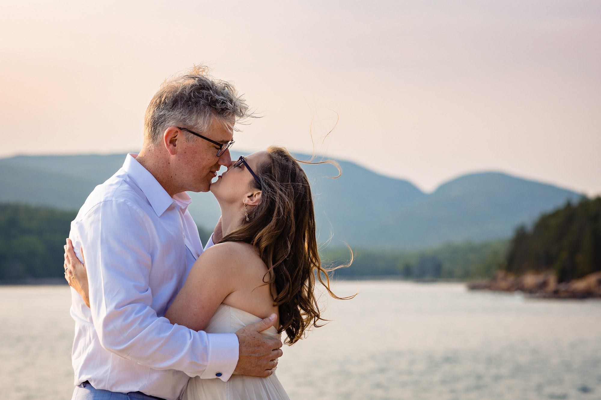 A wedding couple embraces on the cliffs of Acadia