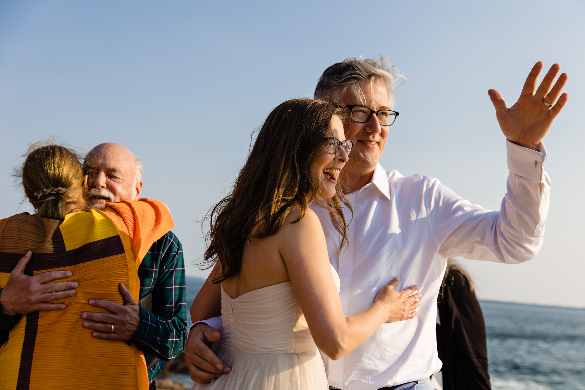 The bride and groom embrace along with the bride's parents at an elopement on Mount Desert Island, Maine