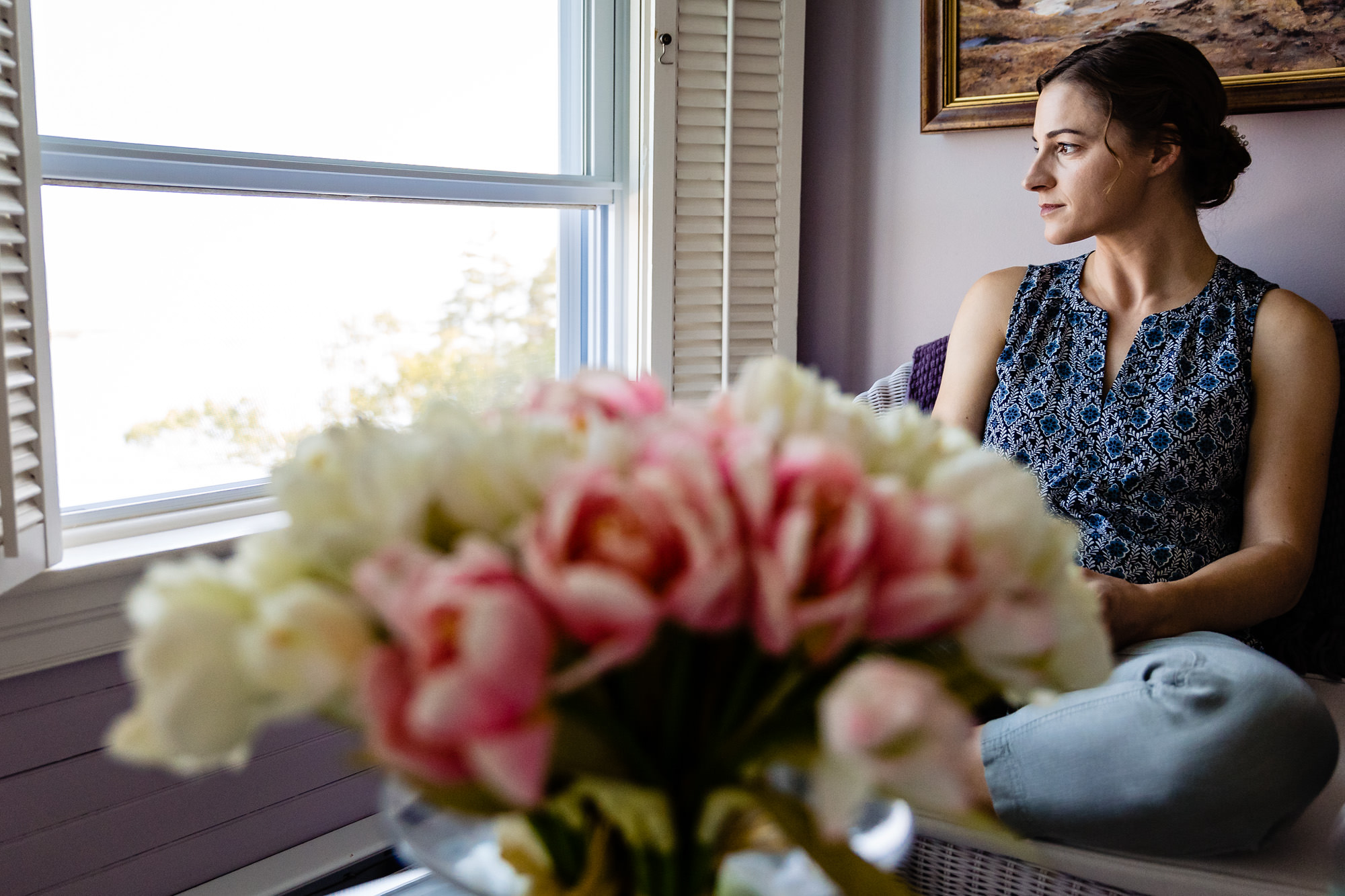 A bride looks out the window awaiting her Grey Havens Inn wedding in Georgetown Maine