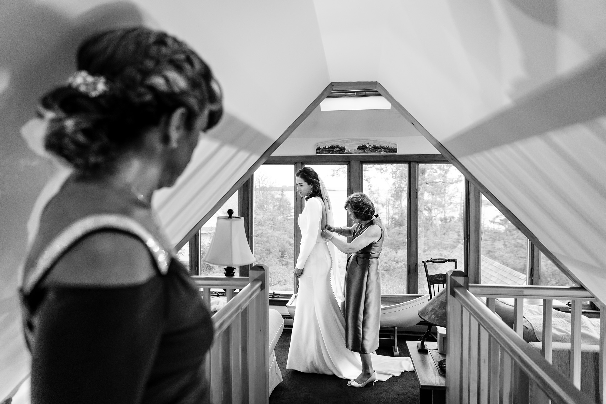 The mother of the bride helps the bride get dressed.