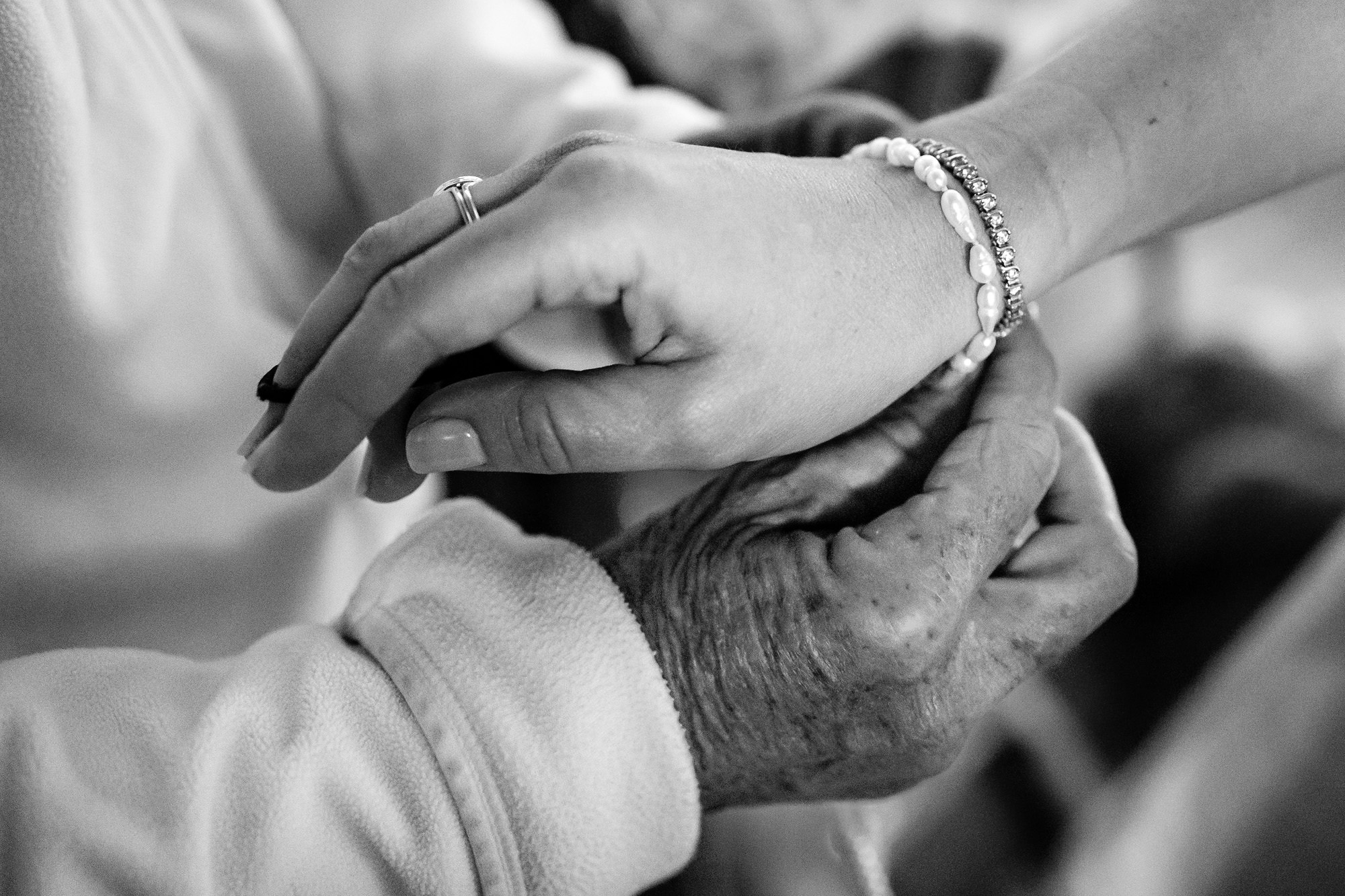 The bride's mom helps to put the bride's bracelet on at her Maine wedding.