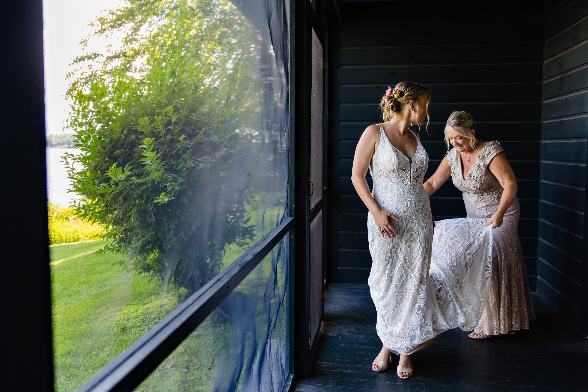 A bride puts on her wedding dress at her Meredith NH wedding ceremony