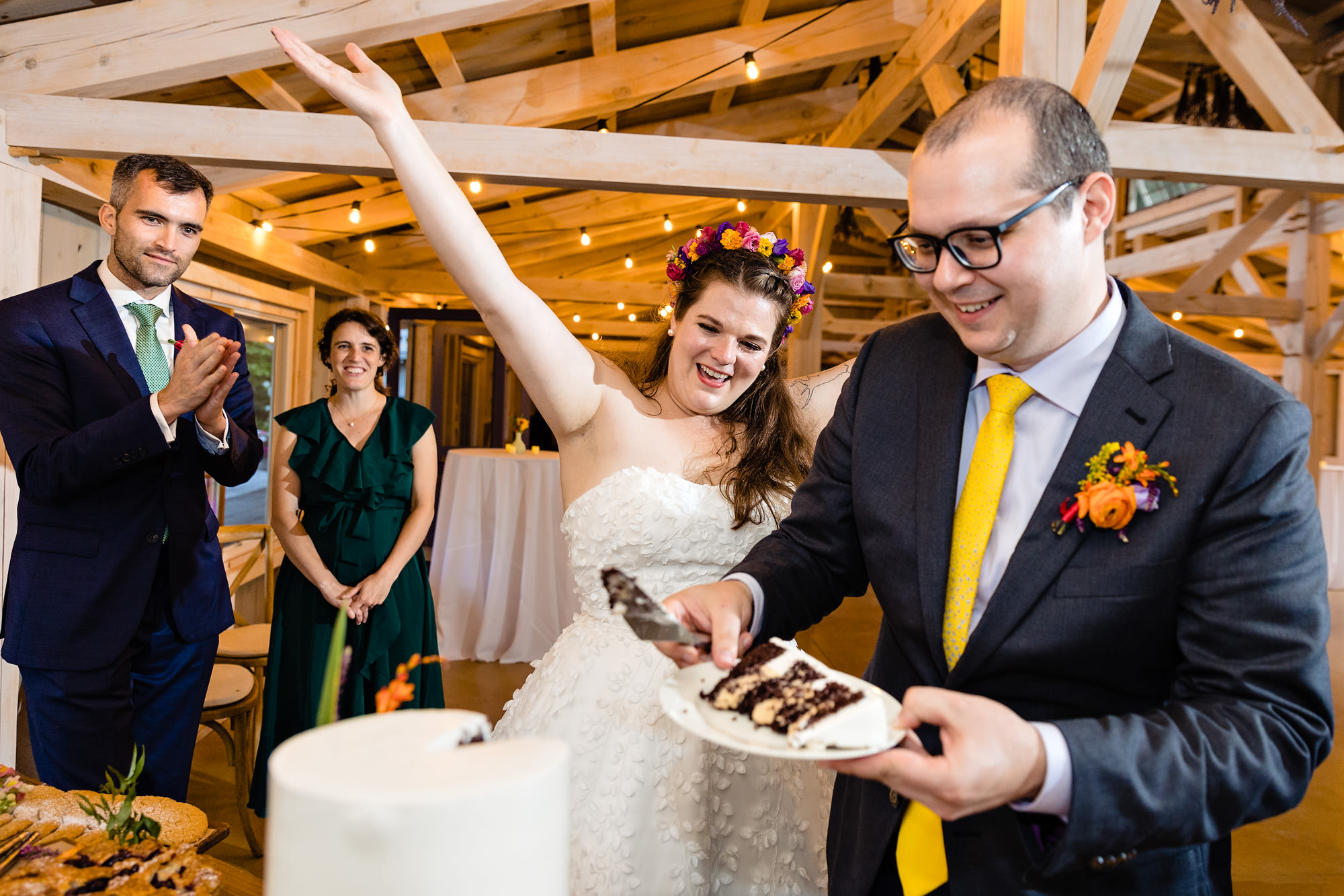 A cake cutting at a wedding in a barn in Maine