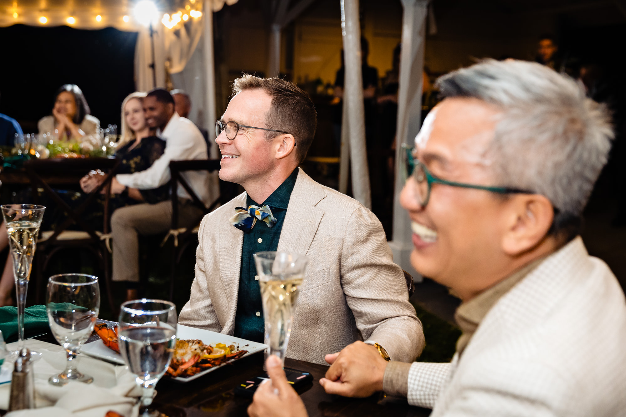 The grooms react to toasts during their wedding in Rangeley, Maine